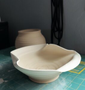 Unglazed bowl with swooping, almost folded edges